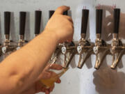 A bartender pours a taster of a beer at Vice Beer in east Vancouver. Vice plans to open a taproom in downtown Vancouver, as well. Top: Beers sit on the bar at Vice Beer in east Vancouver.