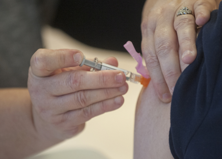A nurse administers a flu shot at Legacy Salmon Creek hospital in Vancouver Friday  December 11, 2015. The center is hosting its free community flu shot clinic Friday afternoon.
