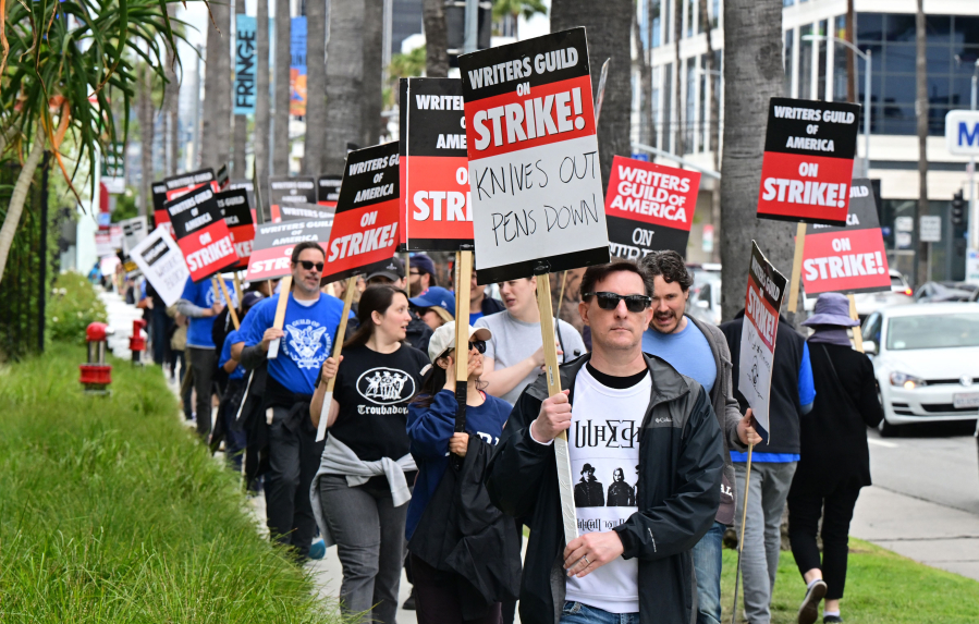 Writer Eric Heisserer hold his sign on the picket line on the fourth day of the strike by the Writers Guild of America in front of Netflix in Hollywood, California, on May 5, 2023. - The Hollywood writers' strike broke out this week over pay, but the refusal of studios like Netflix and Disney to rule out artificial intelligence replacing human scribes in the future has only fueled anger and fear on the picket lines. With their rapidly advancing ability to eerily mimic human conversation, AI programs like ChatGPT have spooked many industries recently. The White House this week summoned Big Tech to discuss the potential risks. (Frederic J.
