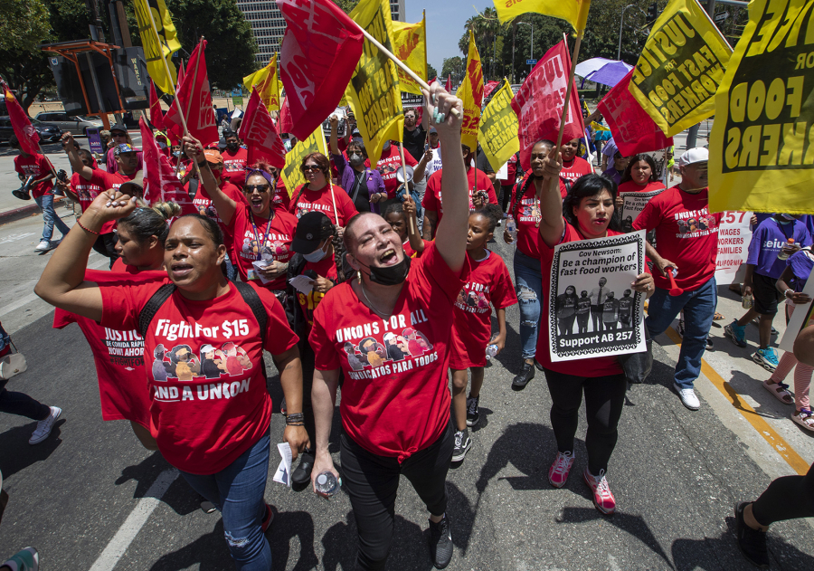 Fast-food workers lead a march to the state building on Spring Street after a rally at Los Angeles City Hall to protest unsafe working conditions, and to demand a voice on the job through AB 257. A coalition of fast-food corporations and business trade groups is seeking to block the law.
