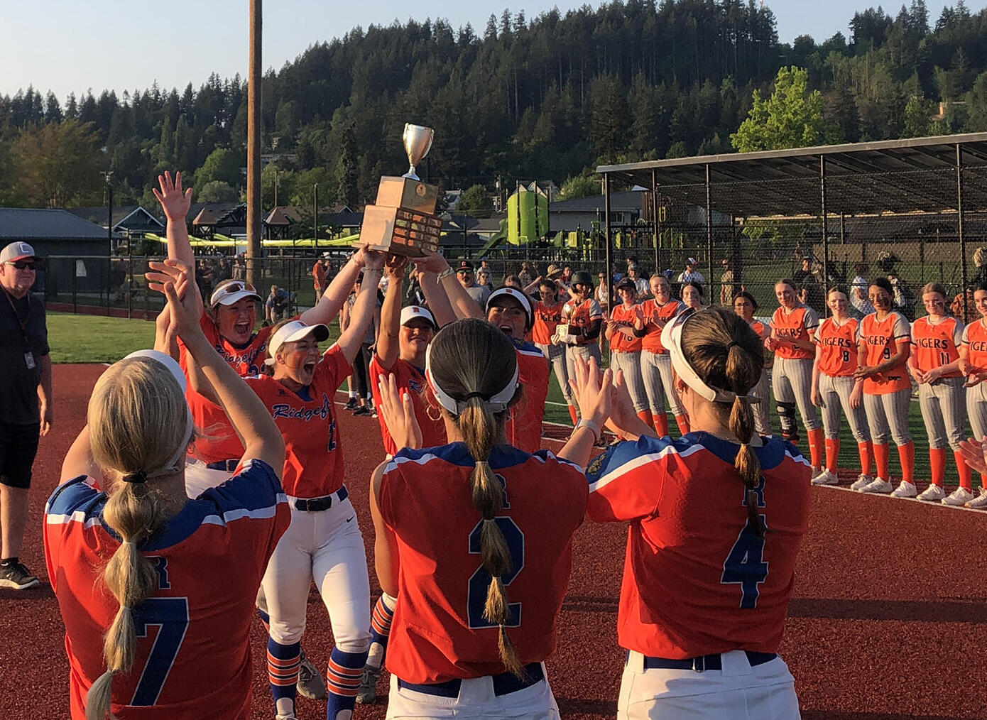 Ridgefield softball players hoist the 2A district trophy after beating Centralia 5-2 in the championship game on Friday, May 19, 2023, at Recreation Park in Chehalis.