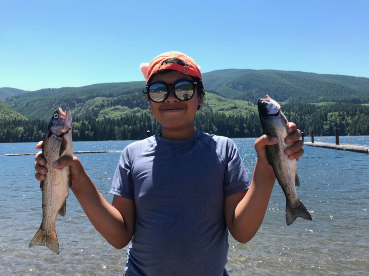 Wesley Thomas of Beaverton, Ore., holds two of the five rainbow trout he caught at Swift Reservoir.