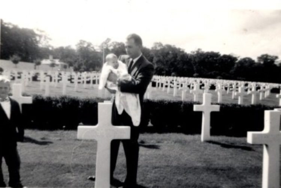 John Reynolds, a 1942 Camas High graduate, holds his infant daughter, Christina, while visiting his brother Arthur Reynolds' gravesite at the Cambridge American Cemetery and Memorial in Coton, England. Arthur Reynolds, also a Camas High graduate, was killed Nov. 10, 1943, during World War II.