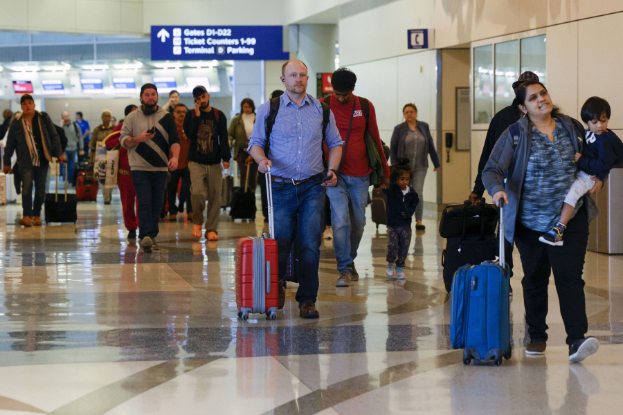 Travelers make their way to a security checkpoint inside Terminal D at Dallas/Fort Worth International Airport, Wednesday, March 1, 2023.