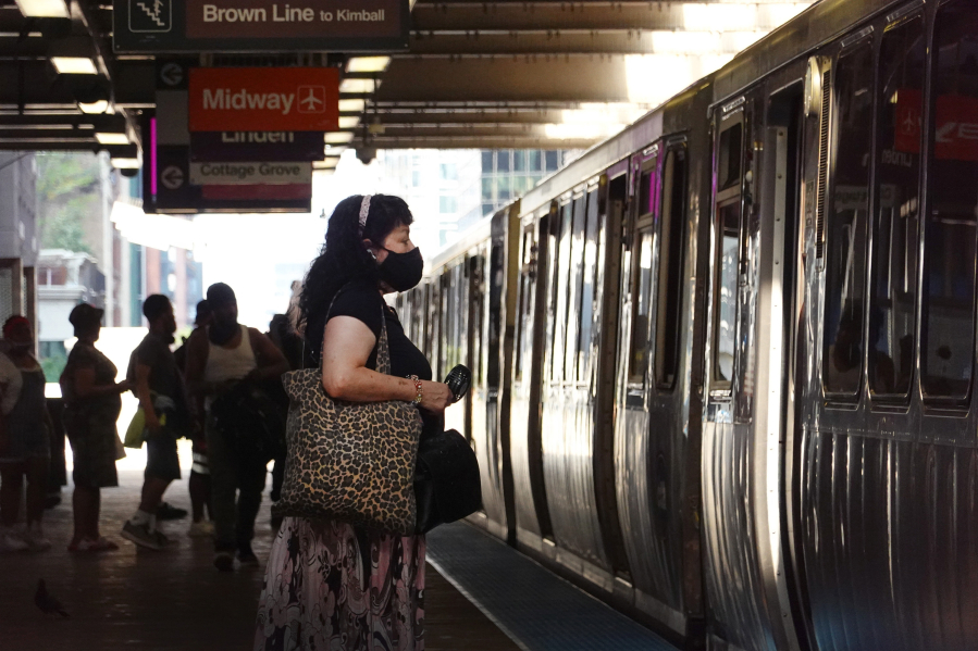 Commuters, most wearing face masks, wait for an L train in the Loop on July 27, 2021, in Chicago.