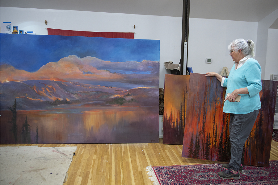 Retired landscape painter Ann Ruttan looks over paintings that depict the Eagle Creek Fire in her Portland home studio the morning of April 3.