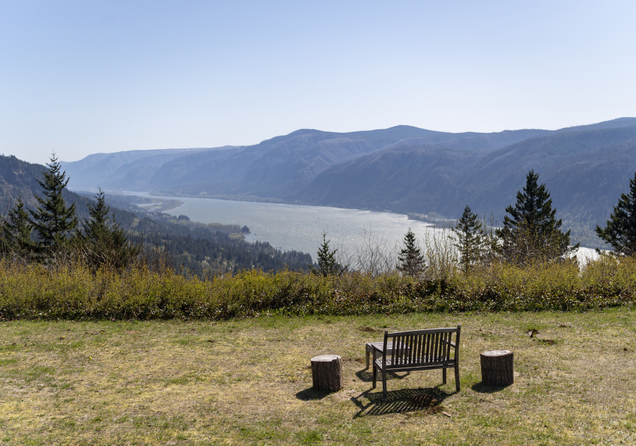 A bench and wooden-stump end tables overlook the Columbia River from Cape Horn Preserve.