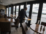 Large windows provide scenic views of the Columbia River for passengers aboard the American Empress as hotel director Terry Lunder prepares the casual dining room for the next meal Monday afternoon.