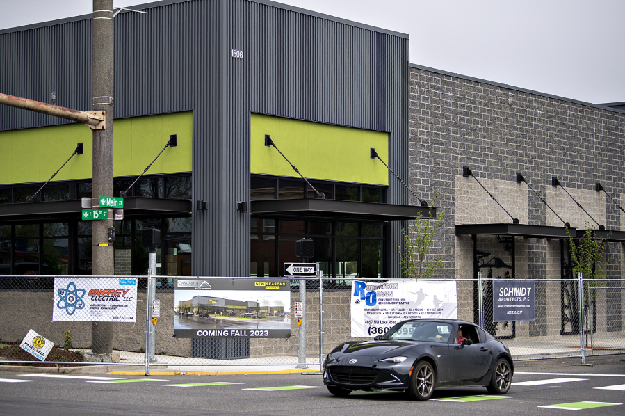 A motorist passes by the New Seasons under construction in Uptown Village on Wednesday morning, May 3, 2023.