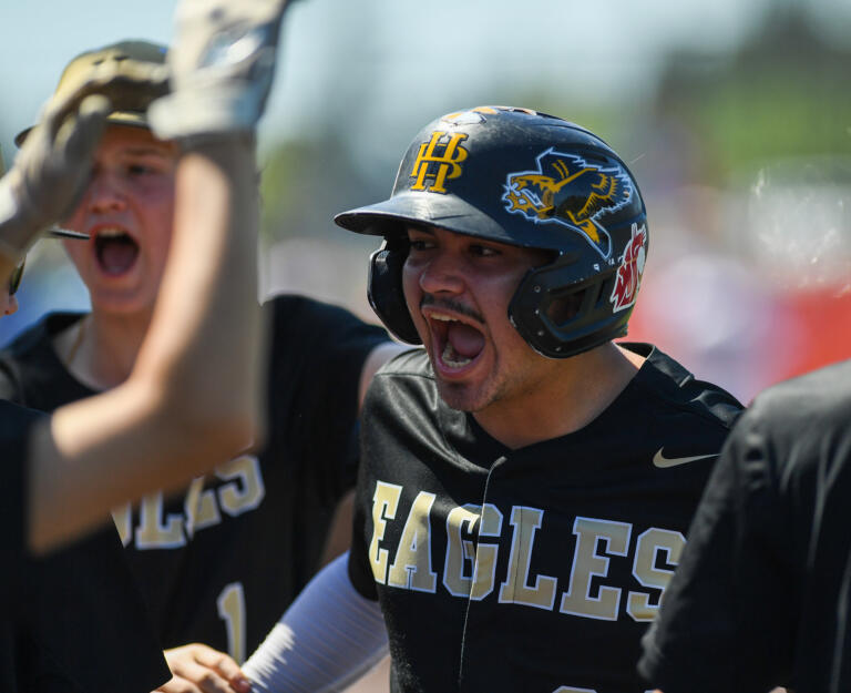 Hudson’s Bay senior Elias Estrada, center, celebrates with the team Friday, May 12, 2023, during the Eagles’ 10-4 win against Ridgefield in a 2A district baseball playoff game at the Ridgefield Outdoor Recreation Complex.