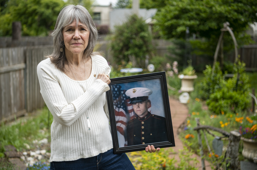 Meredith McMackin holds a portrait of her son, Julian Woodall, in Woodall's memorial garden at the McMackin household in Vancouver. Woodall died 16 years ago while serving in Iraq as a corporal with the U.S. Marine Corps.