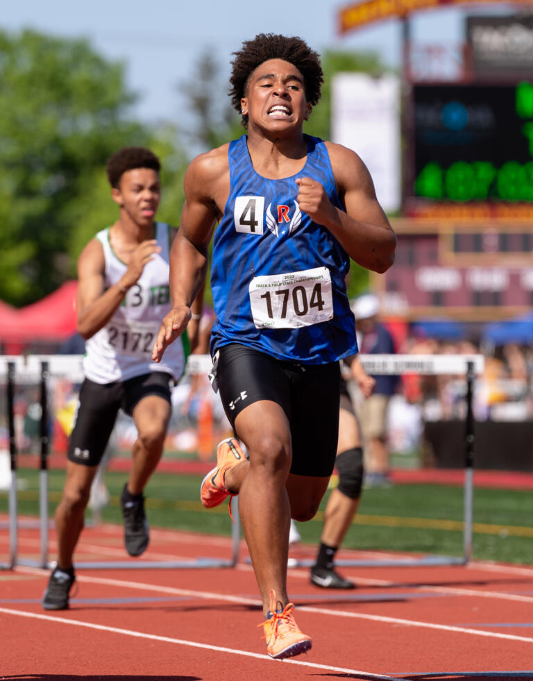 Ridgefield’s Isaiah Cowley stretches for the finish in a preliminary race of the 110-meter hurdles at the WIAA 2A/3A/4A State Track and Field Championships on Thursday, May 25, 2023, at Mount Tahoma High School in Tacoma.