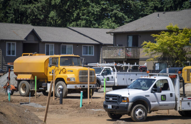 Apartments look over construction vehicles on a site along Northeast 138th Avenue in Vancouver.