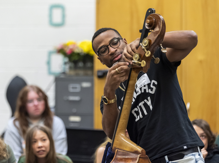 Students watch as Bassist Xavier Foley, right assembles his double bass on Tuesday at Jason Lee Middle School. Foley, who is currently an Artist-in Residence with the Oregon Symphony, said he's played on the same instrument for a decade.