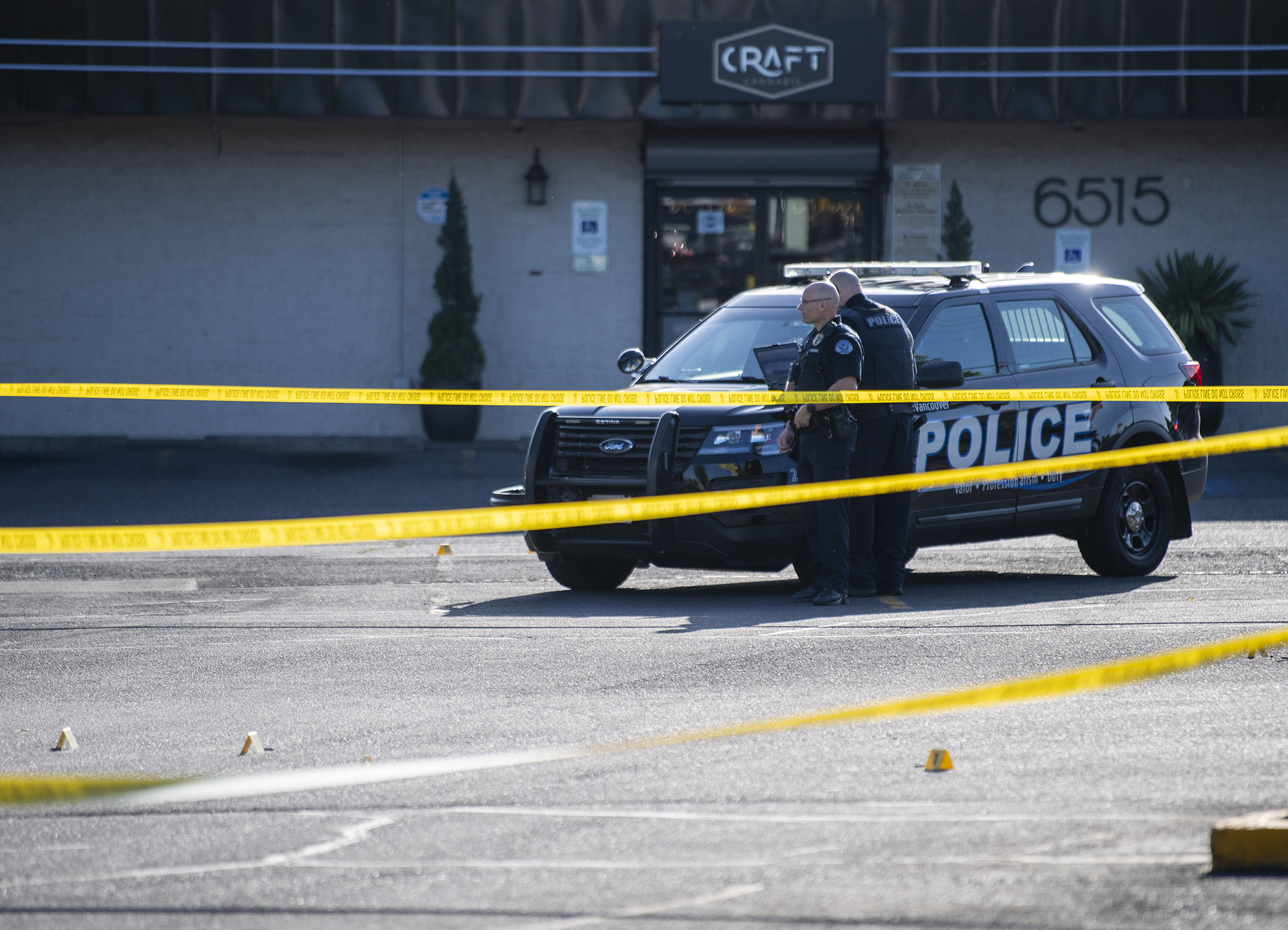 Crime scene tents mark where shell casings lie as Vancouver Police officers stand in the Heights Shopping Center parking lot on Tuesday, May 30, 2023, at the site of a fatal shooting.