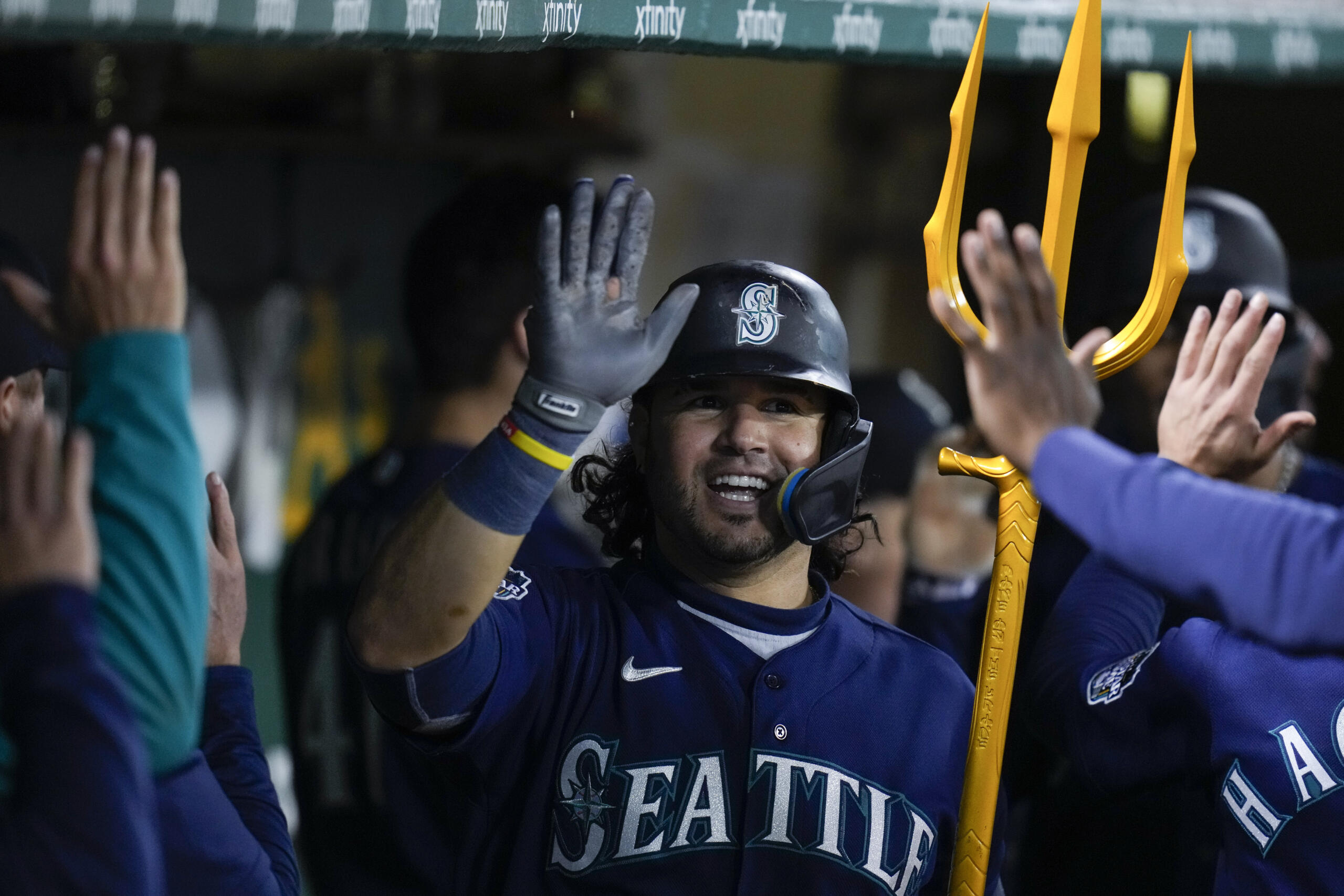 Seattle Mariners' Eugenio Suárez celebrates with teammates in the dugout after hitting a three-run home run against the Oakland Athletics during the 10th inning of a baseball game in Oakland, Calif., Wednesday, May 3, 2023. (AP Photo/Godofredo A.