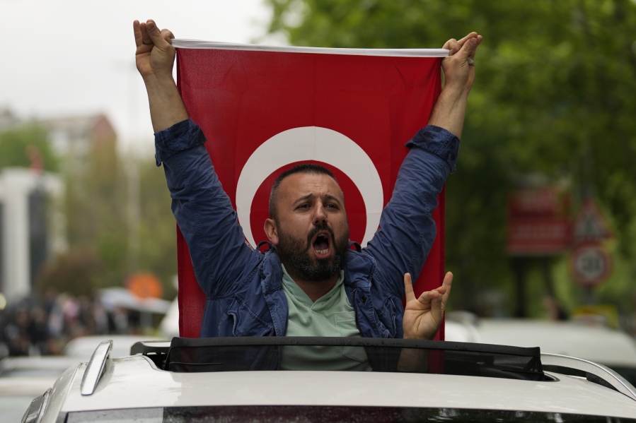 A supporter of the President Recep Tayyip Erdogan holding a Turkish flag shouts slogans outside AK Party offices in Istanbul, Turkey, Sunday, May 28, 2023. Erdogan takes lead in unofficial count in Turkey's presidential runoff.