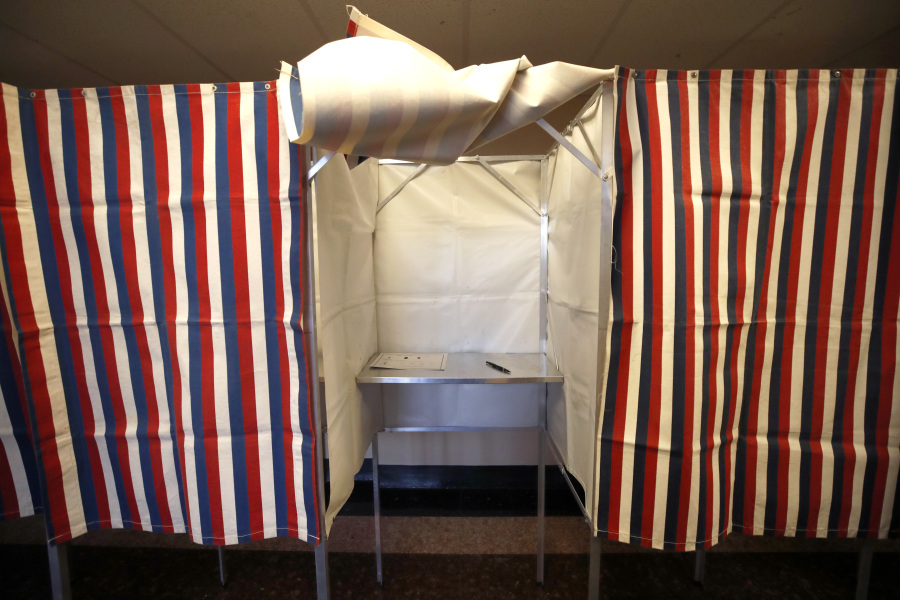 FILE - A booth is ready for a voter, Feb. 24, 2020, at City Hall in Cambridge, Mass., on the first morning of early voting in the state. Thanks to recent advances in artificial intelligence, tools that can create lifelike photos, video and audio are now cheap and readily available. AI experts and political scientists say these new programs will have significant implications for next year's U.S. elections.