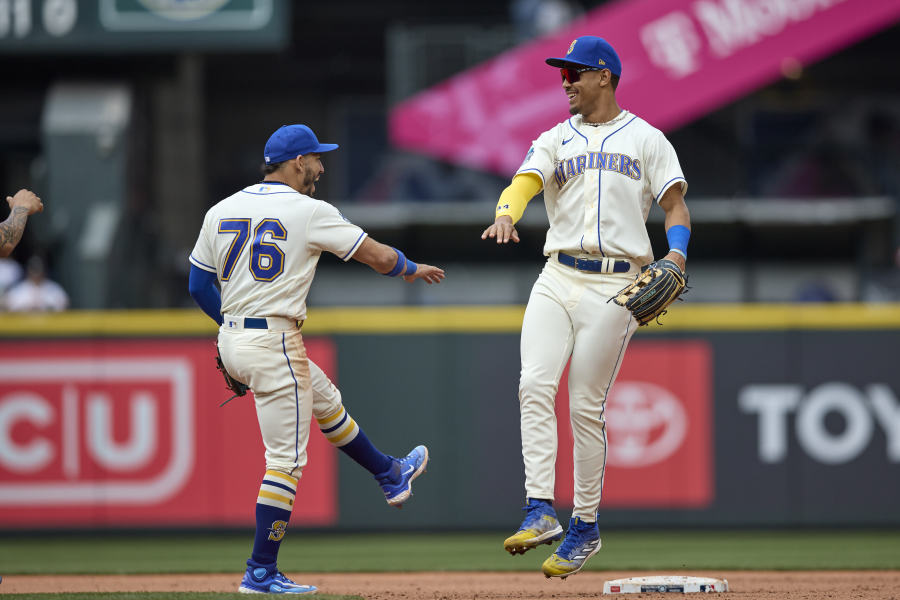 Seattle Mariners second baseman Jose Caballero, left, and center fielder Julio Rodriguez celebrate a win over the Houston Astros in a baseball game, Sunday, May 7, 2023, in Seattle.