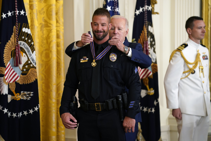 President Joe Biden presents the Medal of Valor, the nation's highest honor for bravery by a public safety officer, to Cpl. Jeffrey Farmer, of the Littletown, Colo., Police Dept., during an event in the East Room of the White House, Wednesday, May 17, 2023, in Washington.