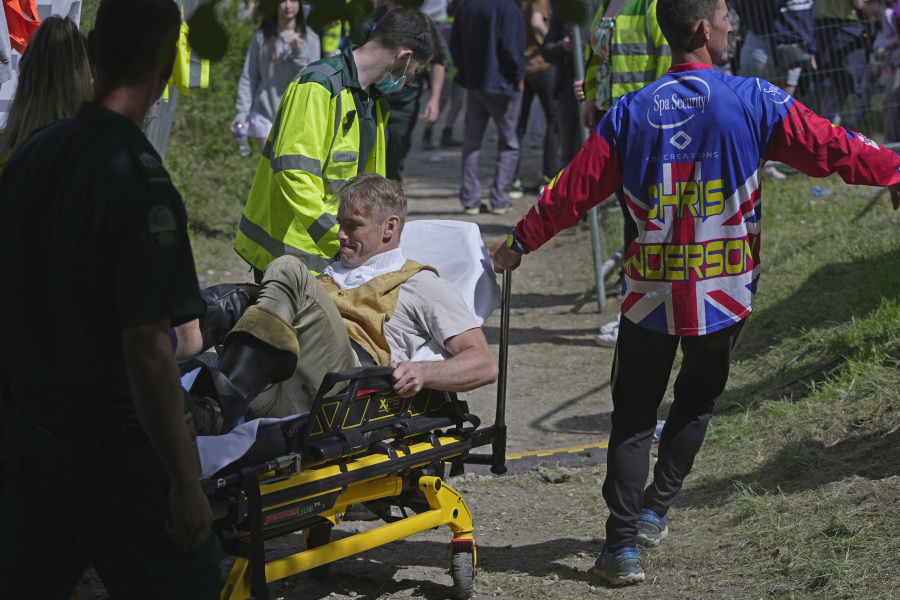 A participant receives medical treatment after the Cheese Rolling contest at Cooper's Hill in Brockworth, Gloucestershire, Monday May 29, 2023. The Cooper's Hill Cheese-Rolling and Wake is an annual event where participants race down the 200-yard (180 m) long hill chasing a wheel of double gloucester cheese.