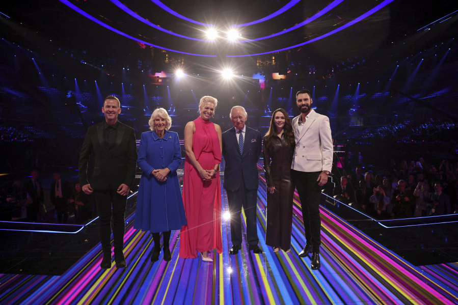 Britain's King Charles III, third from right, and Camilla, the Queen Consort, second from left, pose with the presenters of this year's Eurovision Song Contest, Scott Mills, left, Hannah Waddingham, center, Julia Sanina, second from right, and Rylan Clark, as they visit the host venue of this year's Eurovision Song Contest, the M&S Bank Arena in Liverpool, England, Wednesday, April 26, 2023.