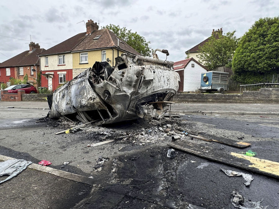 A burnt vehicle is seen at the scene where a riot broke out after two teenagers died in a crash, in Ely, Cardiff, Tuesday May 23, 2023. Several dozen youths pelted police with objects and set cars ablaze on Monday evening in Cardiff in local unrest that erupted after two teenagers died in a road accident.