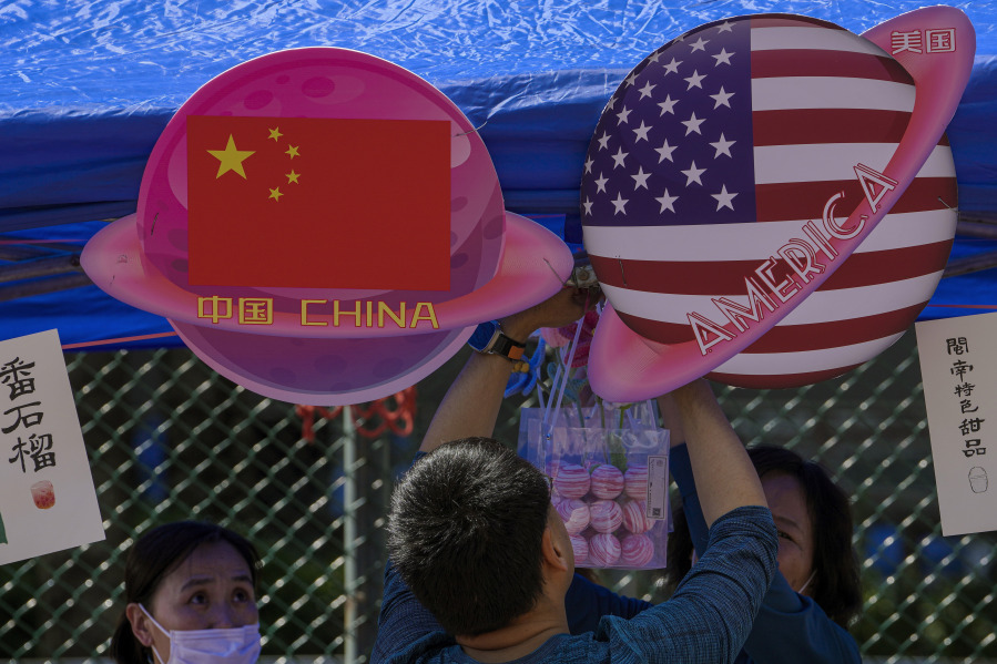 FILE - A vendor sets up foods and beverages at a booth displaying China and American flags during a Spring Carnival in Beijing, on May 13, 2023. China sentenced a 78-year-old United States citizen to life in prison Monday May 15, 2023 on spying charges, in a case that could exacerbate the deterioration in ties between Beijing and Washington over recent years.