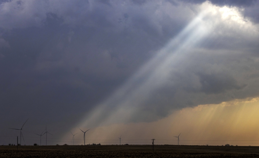 FILE - Sunlight filters through storm clouds onto a wind turbine as severe weather rolls through the midwest on April 4, 2023, south of Stuart, Iowa. The U.S. Department of Agriculture announced a nearly $11 billion investment on Tuesday, May 16, to help bring affordable clean energy to rural communities throughout the country.