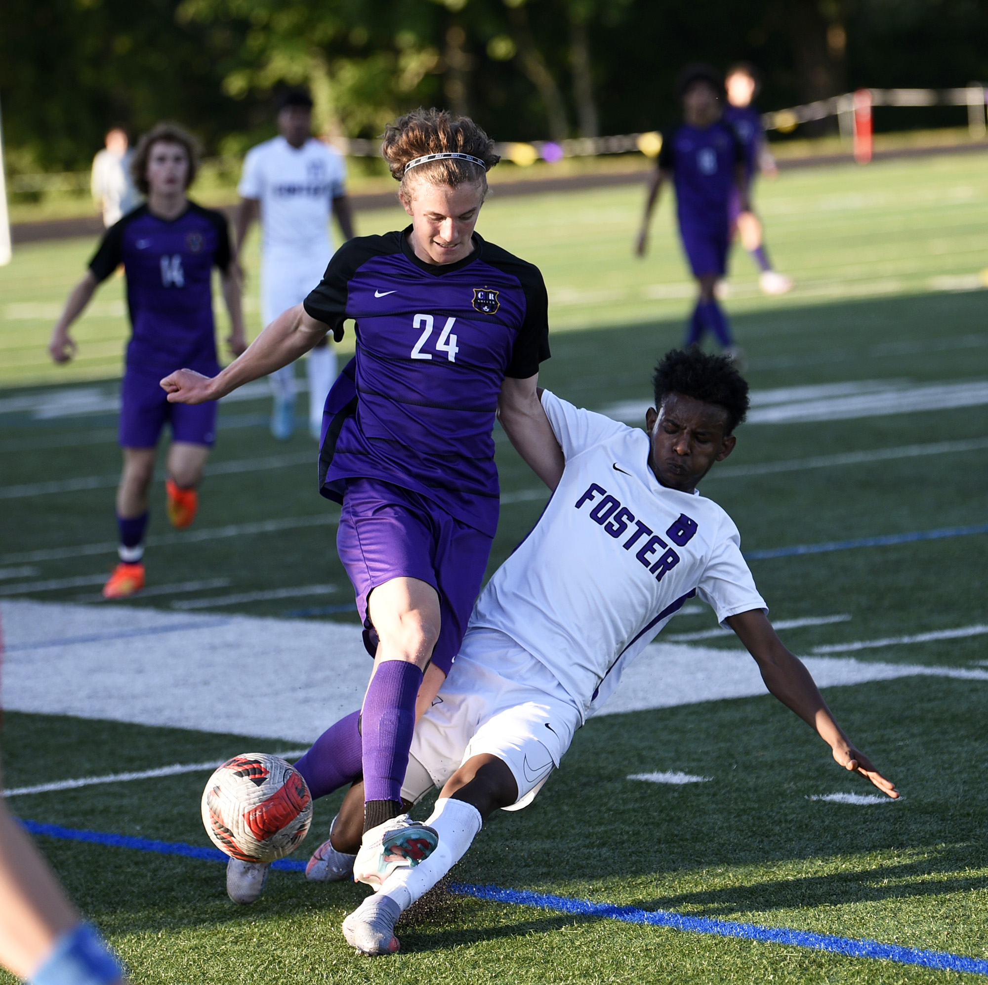 Columbia River's Tyler Brown (24) battles for possession of the ball with Foster's Anawar Kimo during River's 3-0 win in a Class 2A boys soccer state first-round playoff game at Columbia River High School on Wednesday, May 17, 2023.