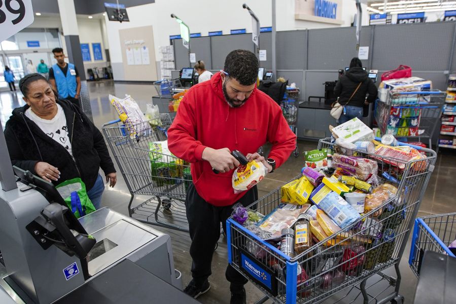 File - Francisco Santana buys groceries at the Walmart Supercenter in North Bergen, N.J. on Thursday, Feb. 9, 2023. On Friday, the Commerce Department issues its April report on consumer spending.