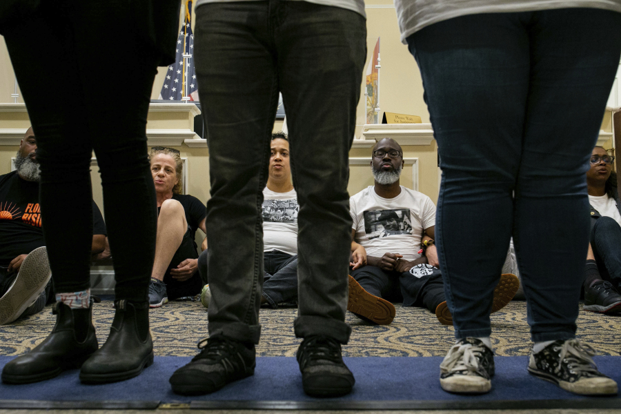 Dozens of activists stage a sit-in outside Florida Gov. Ron DeSantis' office and force people to step over them to reach DeSantis' office as they speak out against the governor and his policies, Wednesday, May 3, 2023, in Tallahassee, Fla.  Florida Republicans on Wednesday approved bills to ban diversity programs in colleges and prevent students and teachers from being required to use pronouns that don't correspond to someone's sex, building on top priorities of the Republican governor.