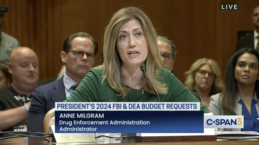 In this image from video provided by C-SPAN, U.S. Drug Enforcement Administration Administrator Anne Milgram speaks during a hearing before the Senate Appropriations Subcommittee on Commerce, Justice, and Science in Washington on May 10, 2023. At center left behind Milgram is Louis Milione. After temporarily leaving the DEA in 2017, like dozens of colleagues in the agency's powerful-but-little-known Office of Diversion Control, Milione immediately went to work as a consultant for some of the same companies he had been tasked with regulating, including Morris & Dickson. He was named deputy administrator in 2021. On another front, a federal watchdog is investigating whether Milgram improperly awarded millions of dollars in no-bid contracts to hire her past associates.