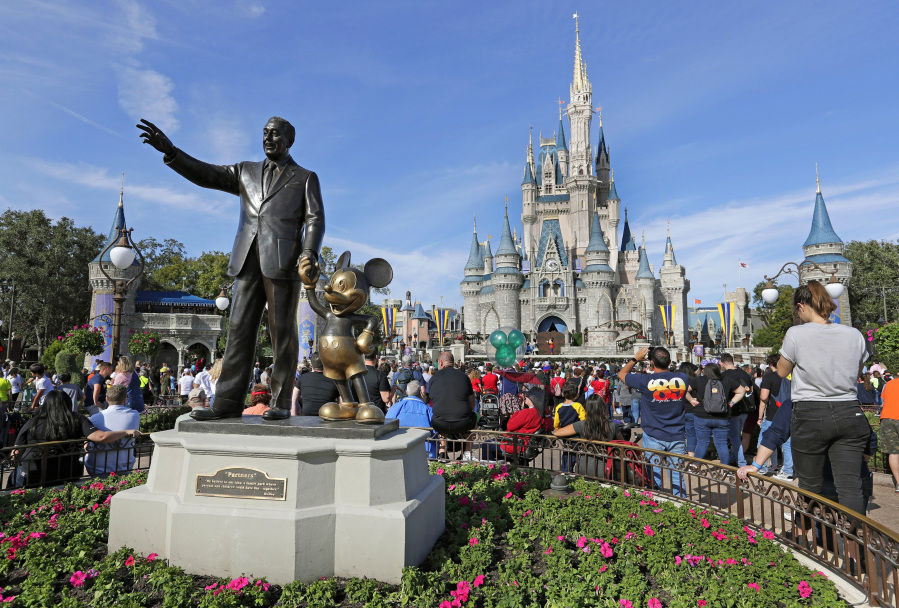 FILE - A statue of Walt Disney and Micky Mouse stands in front of the Cinderella Castle at the Magic Kingdom at Walt Disney World in Lake Buena Vista, Fla., Jan. 9, 2019. It's going on six months since Bob Iger returned to The Walt Disney Co., and while there's been plenty of issues to keep him busy, one has definitely been top of mind: reconnecting with the Disney theme park die-hards and restoring their faith in the brand.