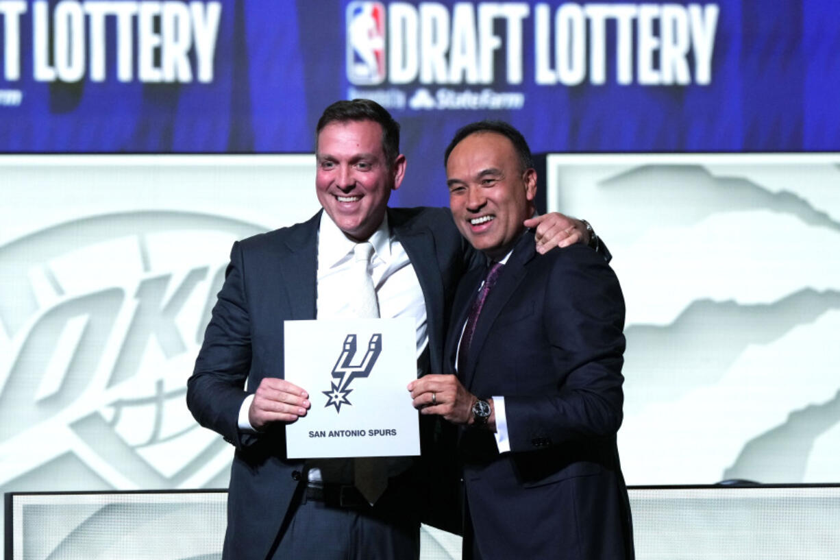 San Antonio Spurs managing partner Peter J. Holt, left, stands with NBA Deputy Commissioner Mark Tatum after Tatum announced that the Spurs won the first pick in the NBA draft, at the draft lottery in Chicago, Tuesday, May 16, 2023. (AP Photo/Nam Y.