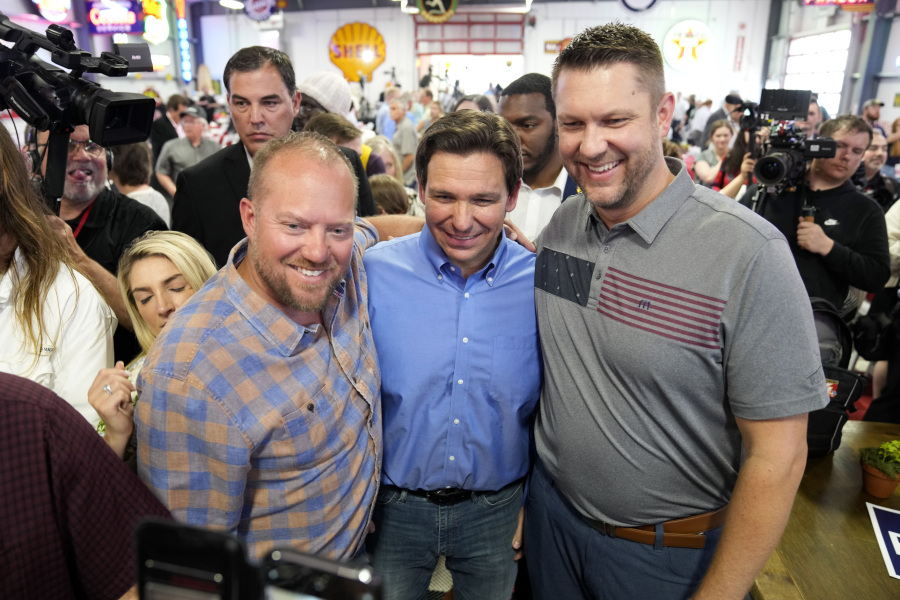 FILE - Florida Gov. Ron DeSantis, center, poses for a photo with audience members during a fundraising picnic forRep. Randy Feenstra, R-Iowa, May 13, 2023, in Sioux Center, Iowa. DeSantis is kicking off his presidential campaign in Iowa at the start of a busy week that will take him to 12 cities in three states as he tests his pitch as the most formidable Republican challenger to former President Donald Trump. (AP Photo/Charlie Neibergall.
