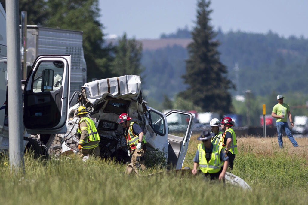 Oregon State Police troopers and firefighters work near the site of a wrecked tractor-trailer Thursday, May 18, 2023,calong Interstate 5 in Albany, Ore. Mulitple people were killed and others hurt in a crash involving multiple vehicles Thursday on Interstate 5 near Albany, Oregon, police said.