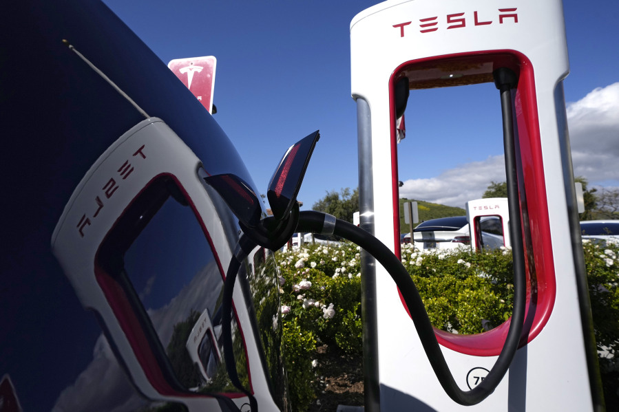 FILE - A Tesla auto charges on May 10, 2023, in Westlake, Calif. All of Ford Motor Co.'s current and future electric vehicles will have access to about 12,000 Tesla Supercharger stations starting in 2024, according to an announcement Thursday, May 25, 2023, by Ford CEO Jim Farley and Tesla CEO Elon Musk. (AP Photo/Mark J.