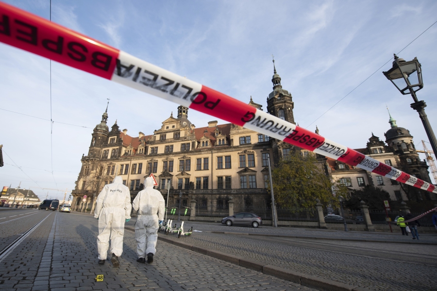 FILE - Police investigators walk in front of the Residenzschloss, Residence Palace, building with the Green Vault in Dresden, Germany, Nov. 25, 2019. A German court on Tuesday May 16, 2023, convicted five men of particularly aggravated arson in combination with dangerous bodily injury, theft with weapons, damage to property and intentional arson in the spectacular theft of 18th-century jewels from the Dresden museum in 2019.