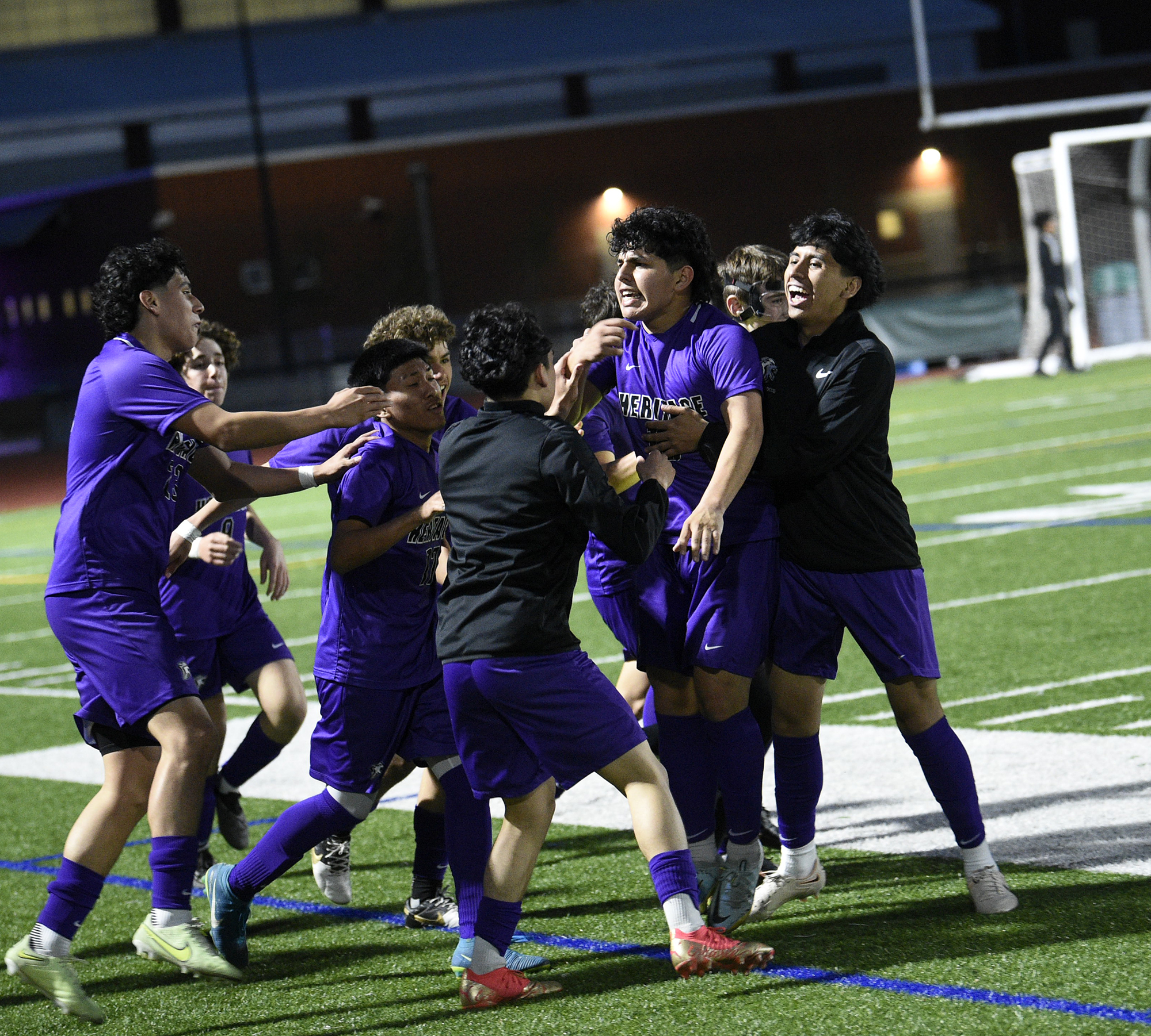 The members of the Heritage boys soccer team celebrate around Pablo Barbosa Sanchez (center) after he scored the overtime goal to beat Mountain View 1-0 at Heritage High School on Wednesday, May 3, 2023.