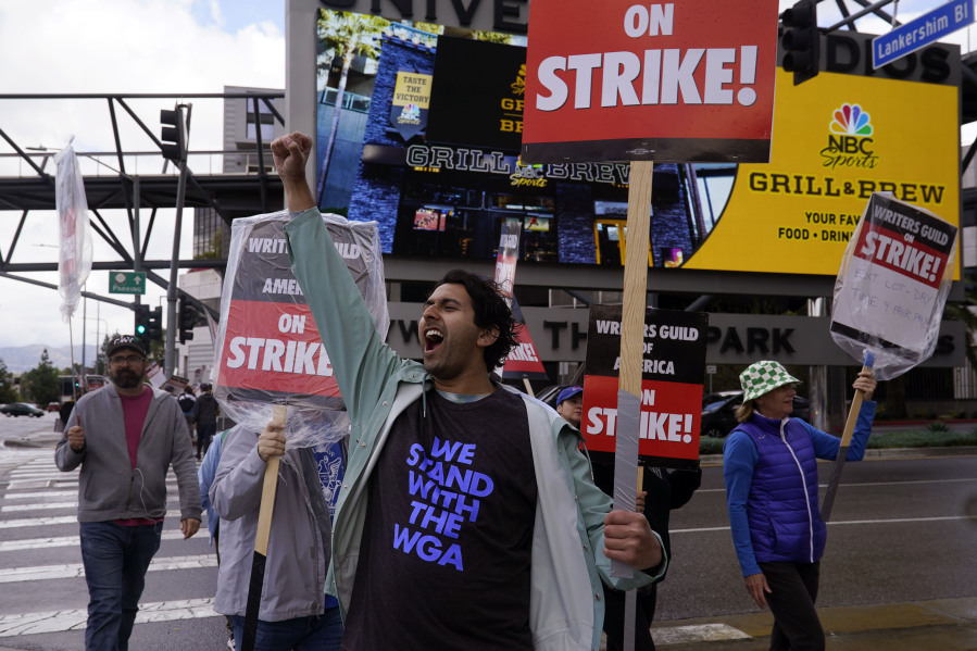 Members of The Writers Guild of America, including actor and writer Cheech Manohar, front center, picket outside of Universal Studios Thursday, May 4, 2023, in Universal City, Calif. The first Hollywood strike in 15 years commenced Tuesday as the 11,500 members of the Writers Guild of America stopped working when their contract expired.
