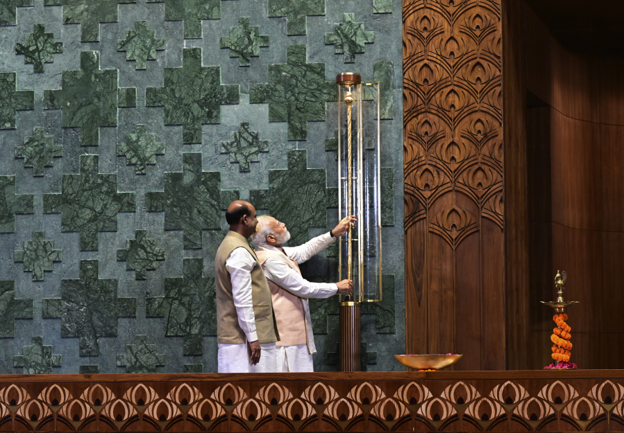 Indian prime minister Narendra Modi installs a royal golden sceptre near the chair of the speaker during the start of the inaugural ceremony of the new parliament building, in New Delhi, India, Sunday, May 28, 2023. The new triangular parliament building, built at an estimated cost of $120 million, is part of a $2.8 billion revamp of British-era offices and residences in central New Delhi called "Central Vista", even as India's major opposition parties boycotted the inauguration, in a rare show of unity against the Hindu nationalist ruling party that has completed nine years in power and is seeking a third term in crucial general elections next year.