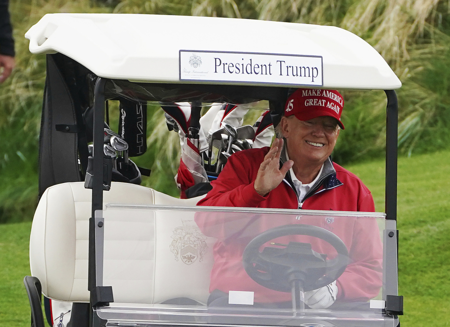 Former US president Donald Trump smiles as he drives in a buggy during a round of golf at Trump International Golf Links & Hotel in Doonbeg, Ireland, Thursday, May 4, 2023, during his visit to Ireland.