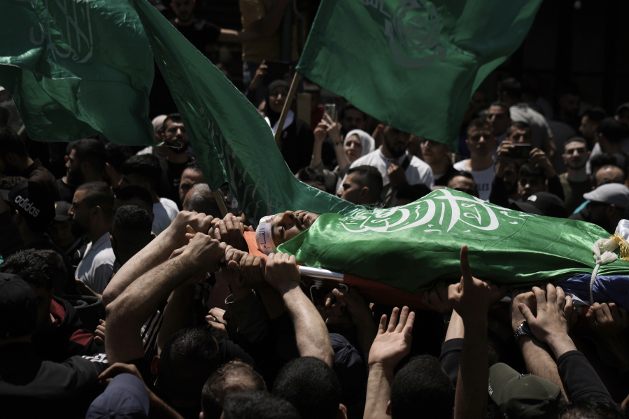 Palestinians carry the body of Hassan Qatnani,, draped in the Hamas militant group flag, during his funeral in the West Bank city of Nablus, Thursday, May 4, 2023. The Israeli military says it has killed Qatnani, Moaz al-Masri and Ibrahim Jabr for being behind an attack last month on a car near a Jewish West Bank settlement that killed a British-Israeli mother and two of her daughters.