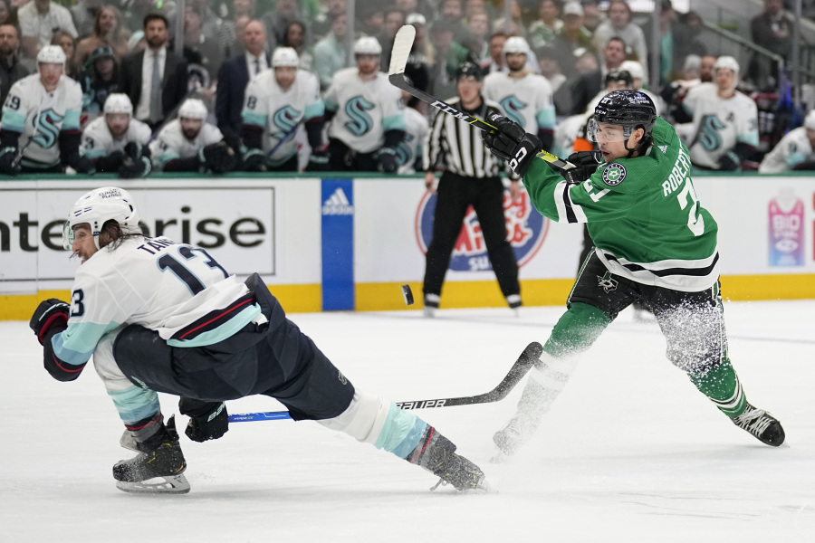 Seattle Kraken left wing Brandon Tanev (13) takes a hit from the puck on a shot by Dallas Stars left wing Jason Robertson (21) in the first period of Game 7 of an NHL hockey Stanley Cup second-round playoff series, Monday, May 15, 2023, in Dallas.