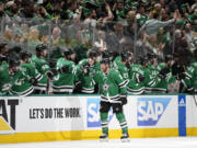 Fans stand and cheer as Dallas Stars center Joe Pavelski, front center, celebrates with the bench after scoring against the Seattle Kraken in the second period of Game 2 of an NHL hockey Stanley Cup second-round playoff series, Thursday, May 4, 2023, in Dallas.