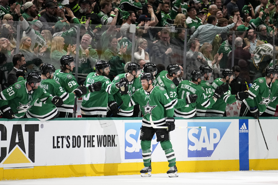 Fans stand and cheer as Dallas Stars center Joe Pavelski, front center, celebrates with the bench after scoring against the Seattle Kraken in the second period of Game 2 of an NHL hockey Stanley Cup second-round playoff series, Thursday, May 4, 2023, in Dallas.
