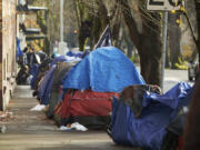 FILE - Tents line the sidewalk on SW Clay St in Portland, Ore., on Dec. 9, 2020. Portland will remove tents blocking sidewalks under a tentative settlement announced Thursday, May 25, 2023, in a lawsuit brought by people with disabilities who said sprawling homeless encampments prevent them from navigating Oregon's most populous city.