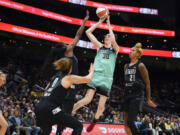 New York Liberty forward Breanna Stewart (30) shoots from between Seattle Storm guard Kia Nurse (0), center Ezi Magbegor and center Mercedes Russell (21) during the first half of a WNBA basketball game Tuesday, May 30, 2023, in Seattle.