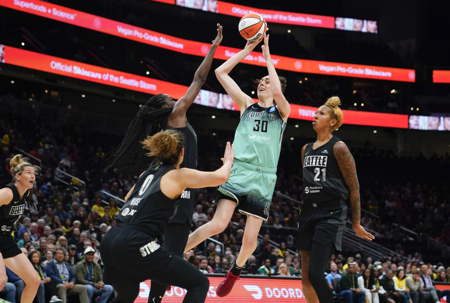 New York Liberty forward Breanna Stewart (30) shoots from between Seattle Storm guard Kia Nurse (0), center Ezi Magbegor and center Mercedes Russell (21) during the first half of a WNBA basketball game Tuesday, May 30, 2023, in Seattle.
